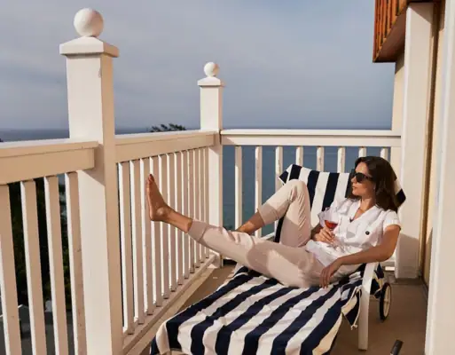 Balkon Nordperd & Villen Eine Frau sitzt auf einem Stuhl auf einem Deck.