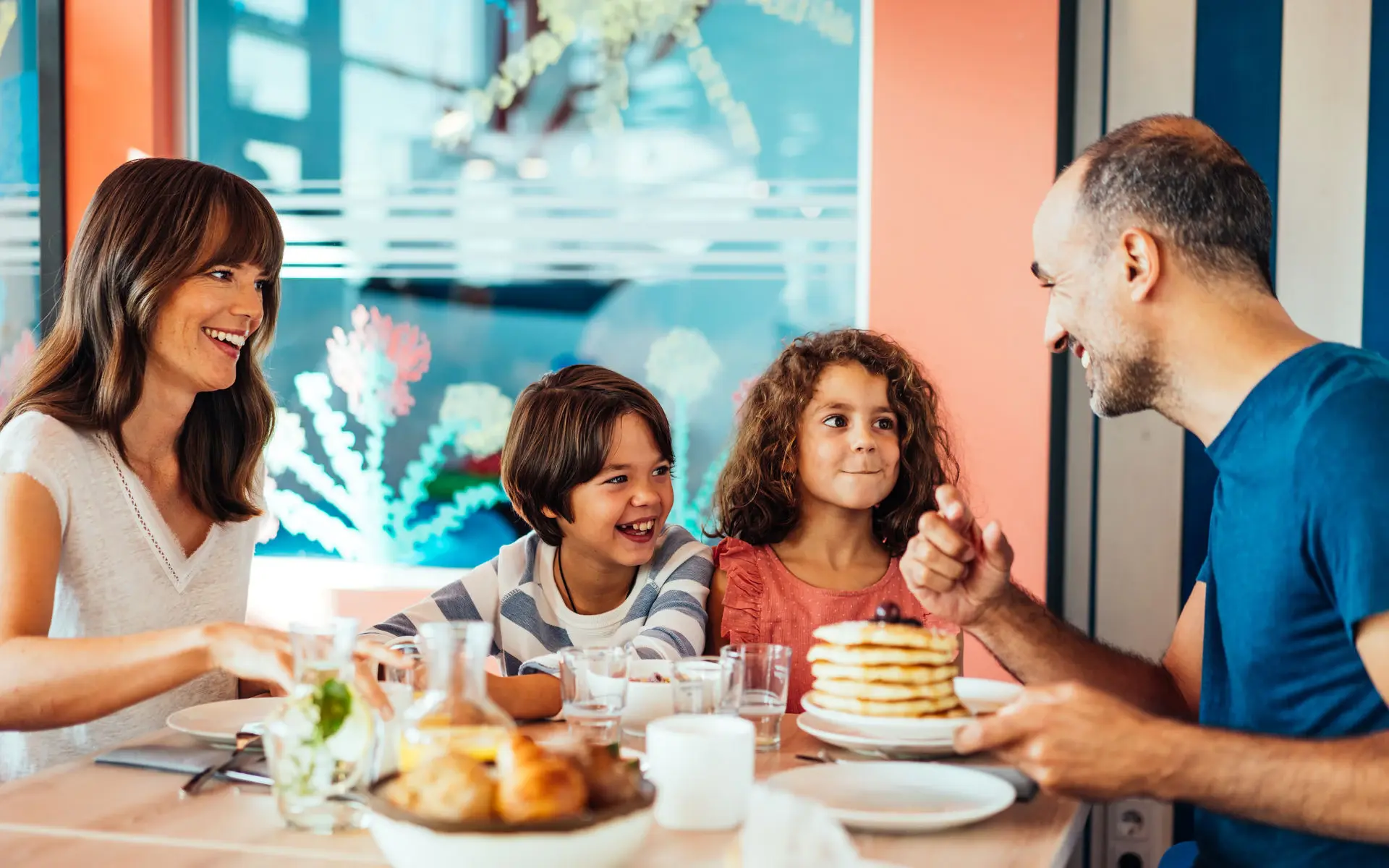 Eine Familie sitzt am Frühstückstisch.