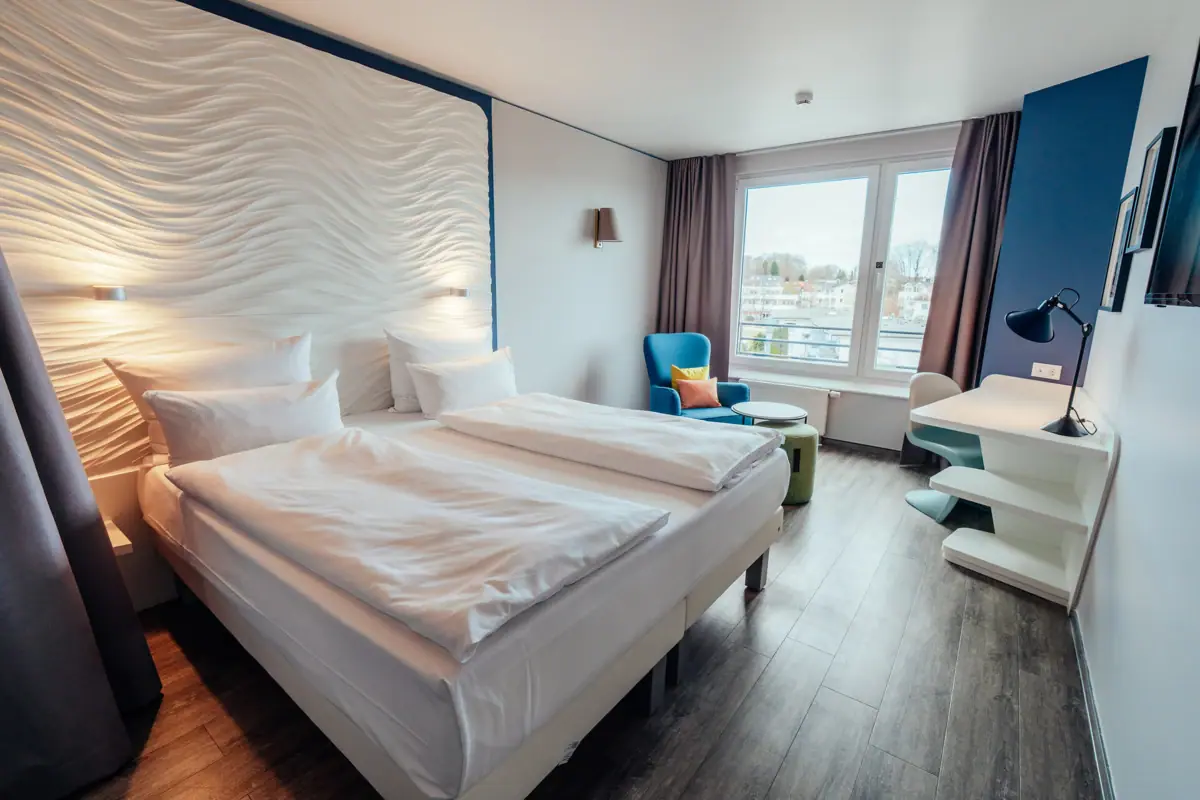 Doppelzimmer Ein Raum mit zwei Betten und einem Tisch.