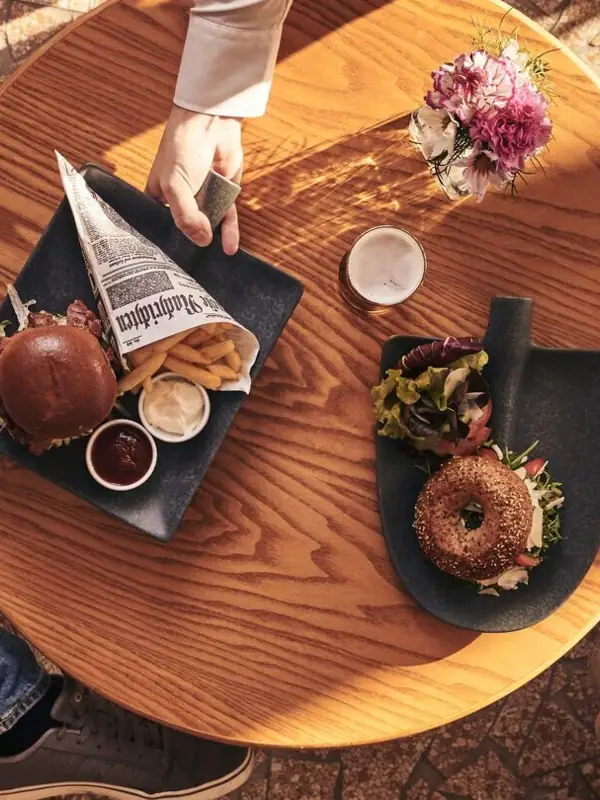 Snacks Eine Person hält einen Teller mit Essen an einem Tisch.