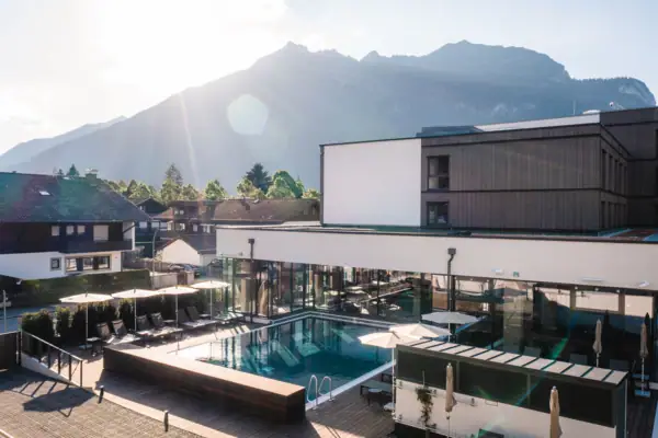 Außenpool Ein Pool in einem Gebäude mit einem Berg im Hintergrund.