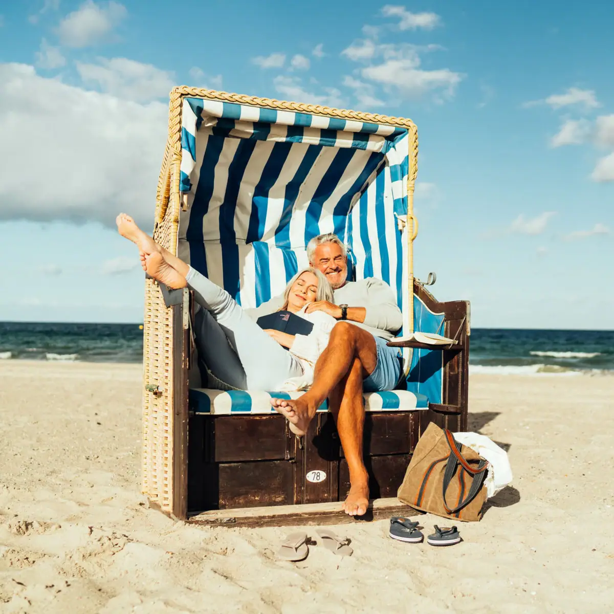 Strandkorb Ein Mann und eine Frau sitzen in einem Strandkorb am Strand.