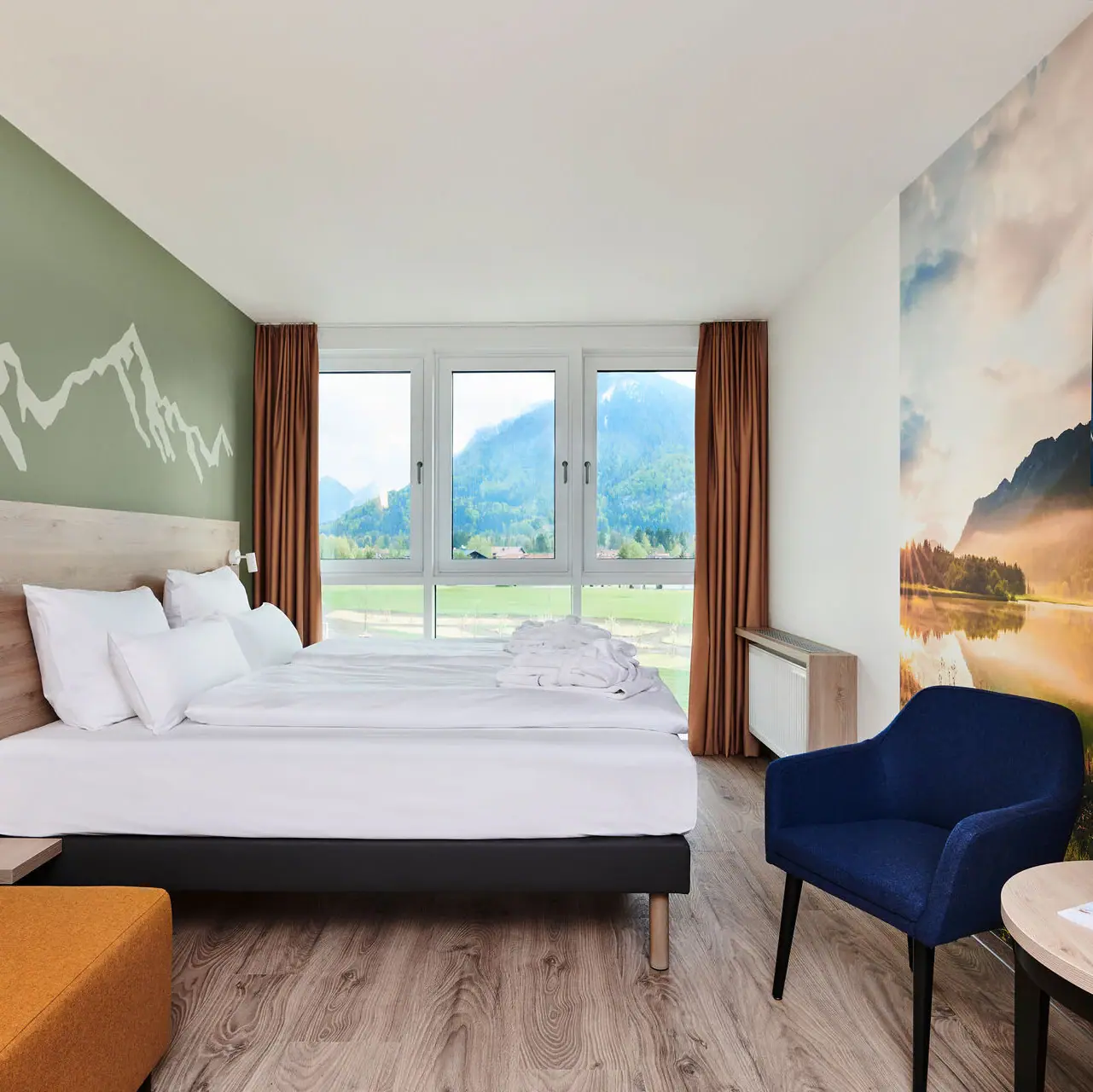 Zimmer im aja Ruhpolding Ein Raum mit einem Bett und Aussicht auf die Berge aus dem Fenster des aja Ruhpolding.