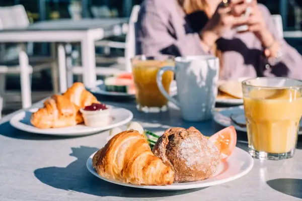 Brötchen und Brot Ein Teller mit Frühstück auf einem Tisch.