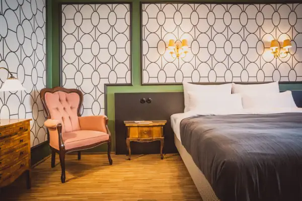 Zimmer im HENRI Wien Ein Schlafzimmer mit einem Bett und einem Stuhl.