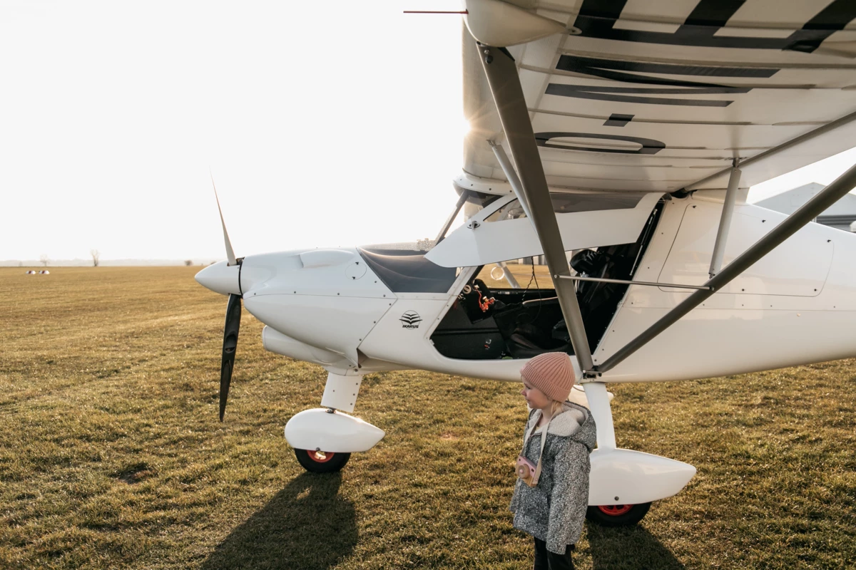 Segelflieger Ein Kind steht vor einem kleinen Flugzeug.