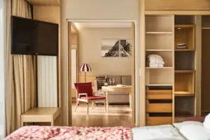 Suite Wohnbereich Ein Zimmer mit einem Fernseher und einem Stuhl.