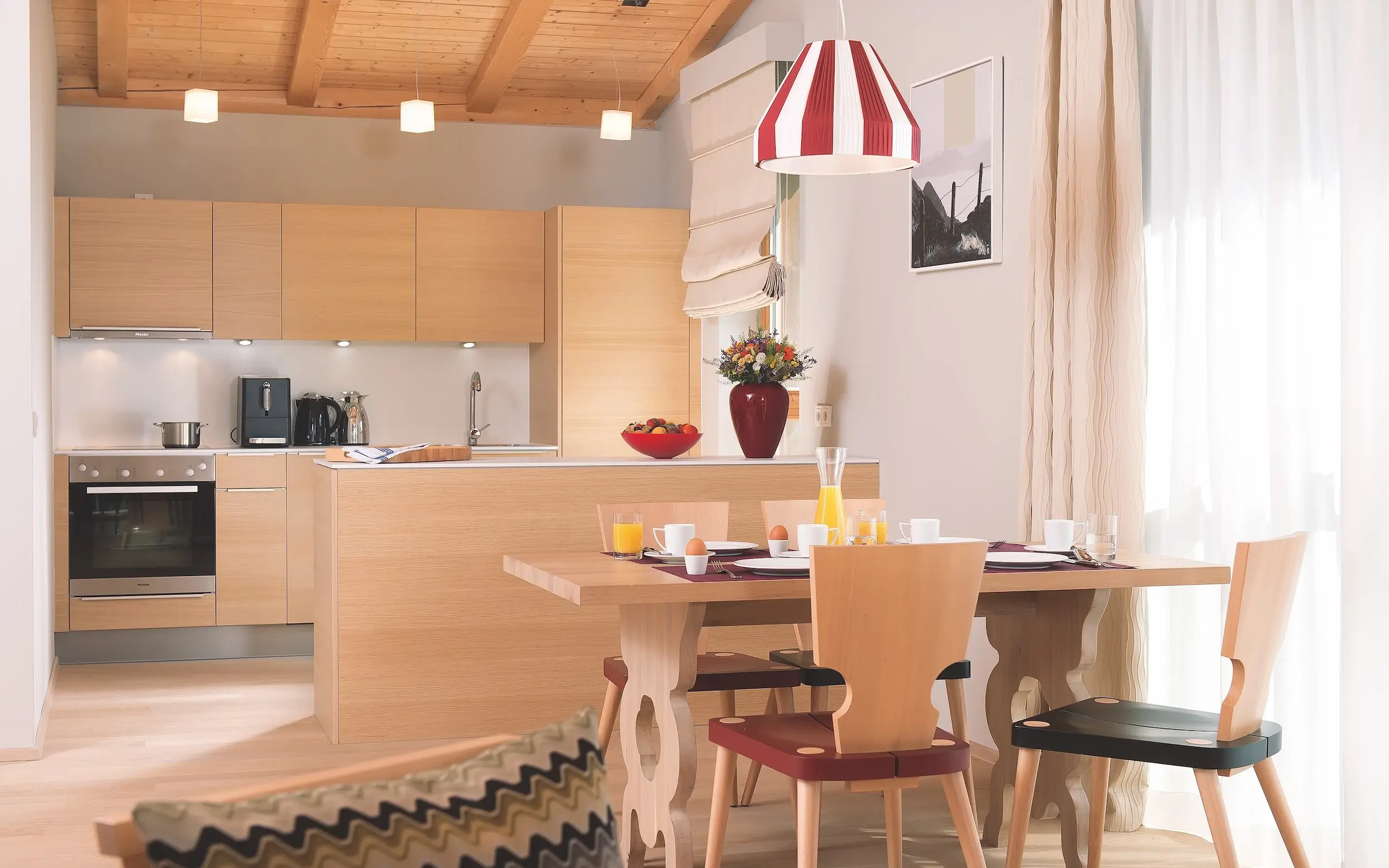 Küche Ferienwohnung Werfenweng Moderne Küche und Esszimmer mit Tisch und Stühlen, eingebauten Schränken und Küchengeräten.