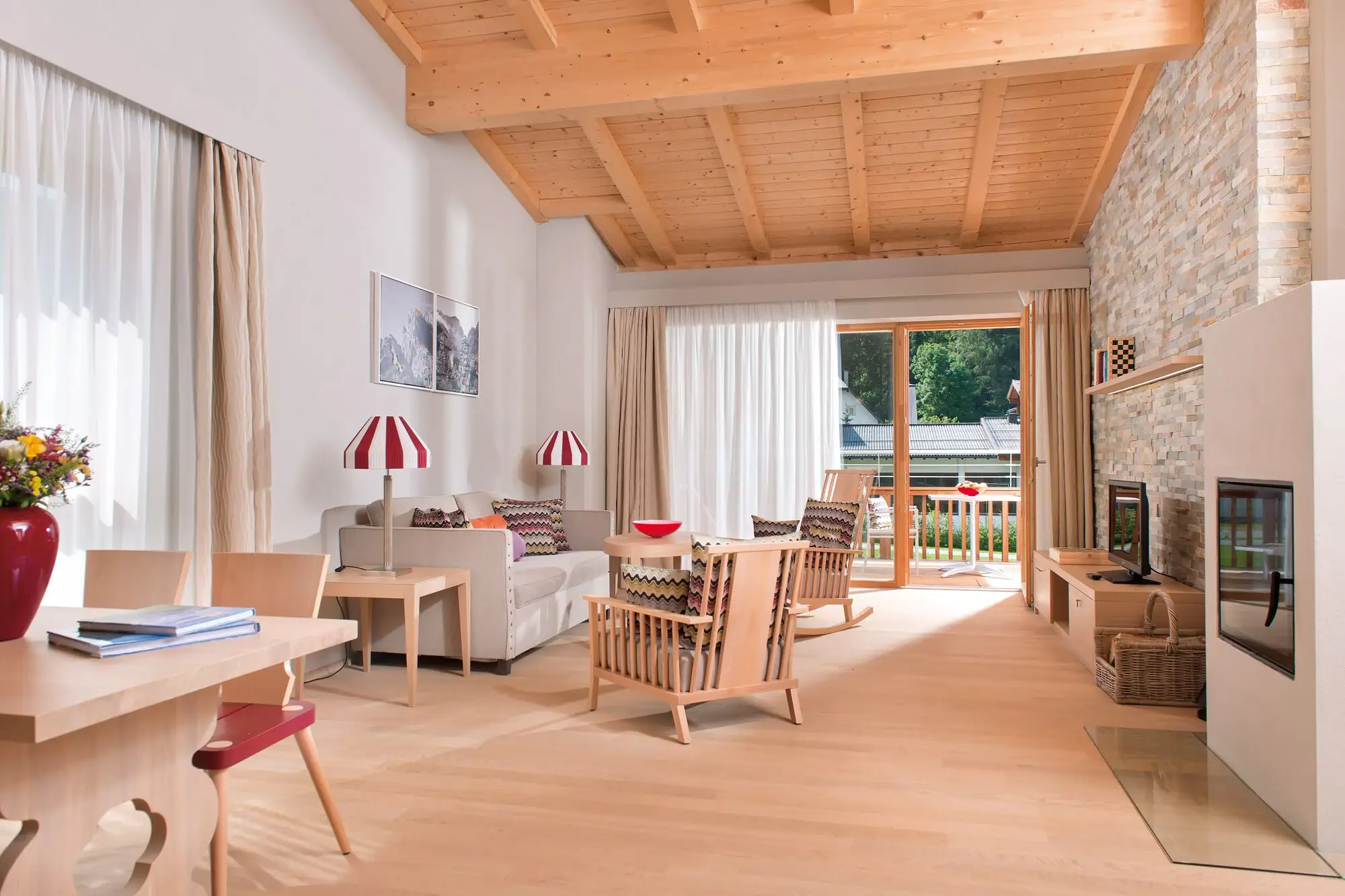 Ferienwohnungen Werfenweng Wohnzimmer mit Kamin und Sofa.