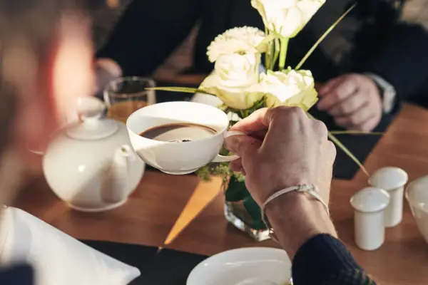 Kaffee Eine Person hält eine Tasse Kaffee.