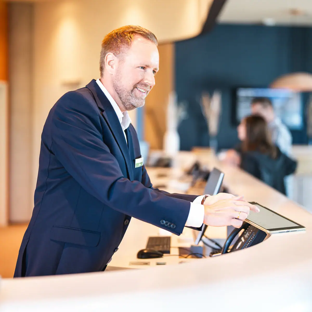 Empfang Ein Mann steht an einem Tresen.