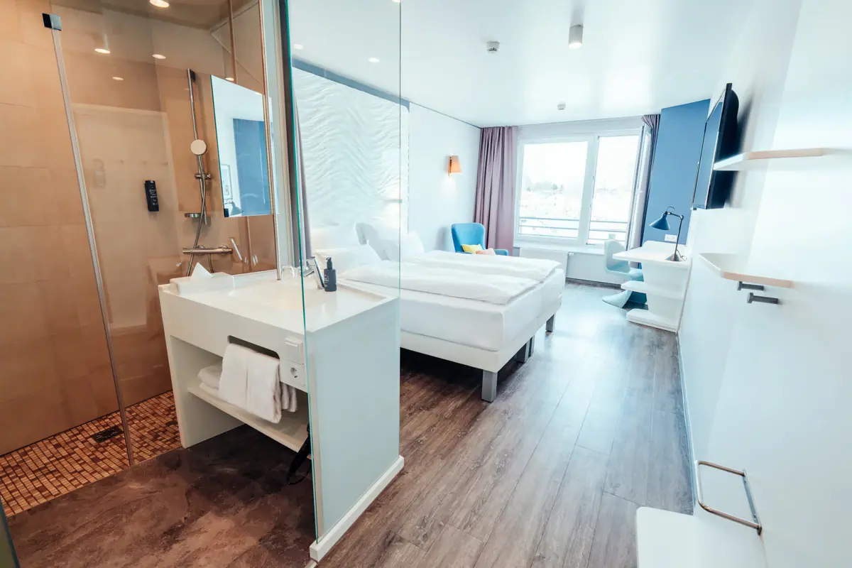 Doppelzimmer mit Bad Ein Raum mit zwei Betten und einer Dusche.