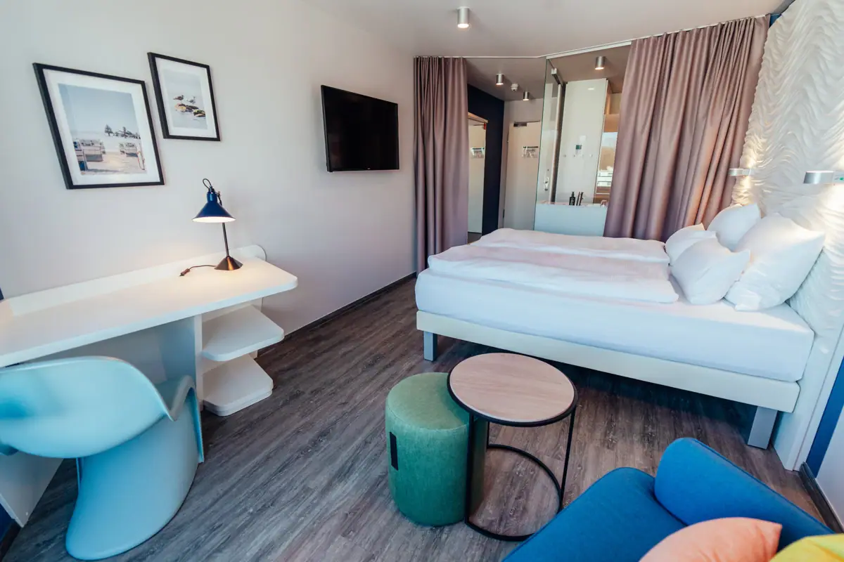 Doppelzimmer Ein Zimmer mit einem Bett, einem Tisch und einem Stuhl.