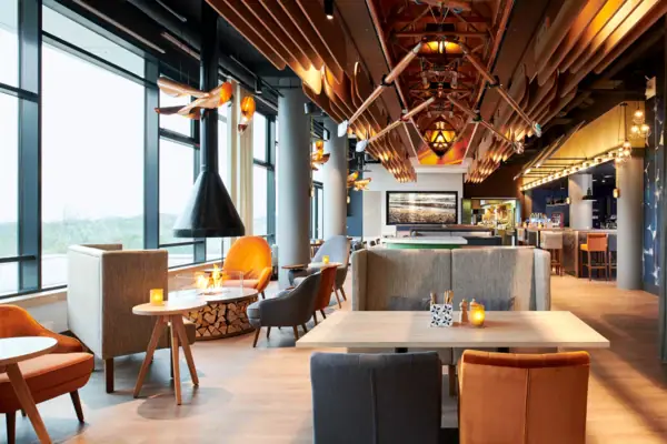 Restaurant und Bar im aja Warnemünde Ein Restaurant mit Tischen und Stühlen, modern eingerichtet.