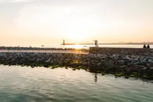 Warnemünde Eine Gruppe von Menschen steht am Wasser.