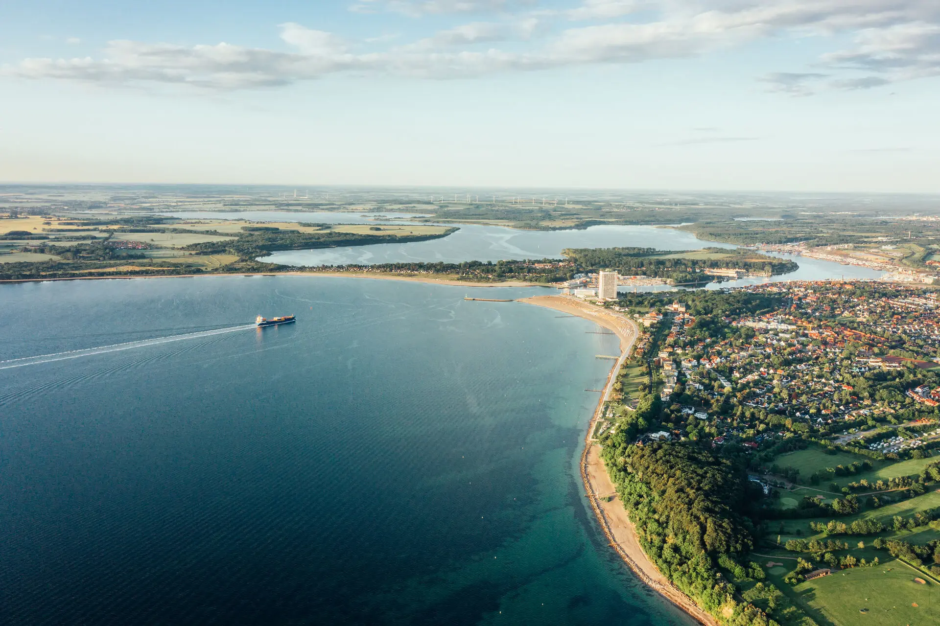 Lübecker Bucht Stadtlandschaft umgeben von vielen Bäumen am Ufer eines Sees