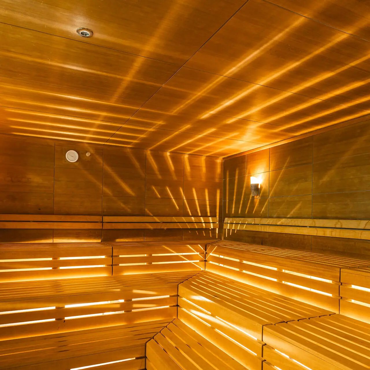 Sauna im aja Bad Saarow Holzsauna mit Licht, das durch die Wände scheint.