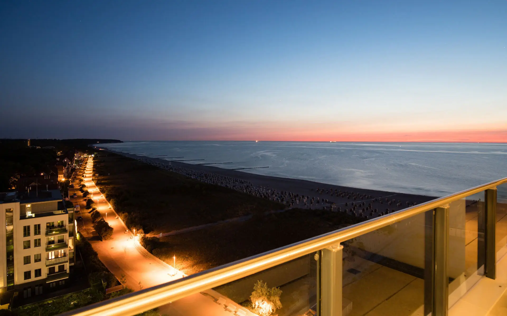 Ausblick von einem Balkon auf das Meer bei Abenddämmerung