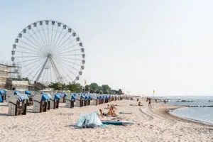 Strand Strand mit Riesenrad und Menschen im Vordergrund.