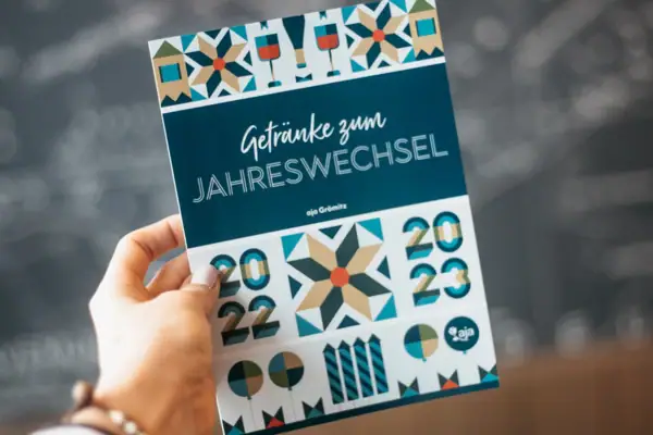 Silvester im aja Grömitz Eine Hand hält ein Programmheft der Silvesterparty.