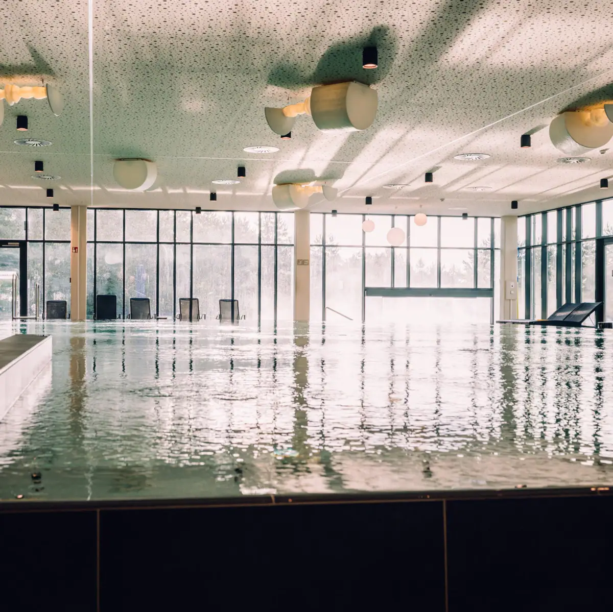 Day SPA im aja Bad Saarow Großes Hallenbad mit großen Wänden und Fenstern.