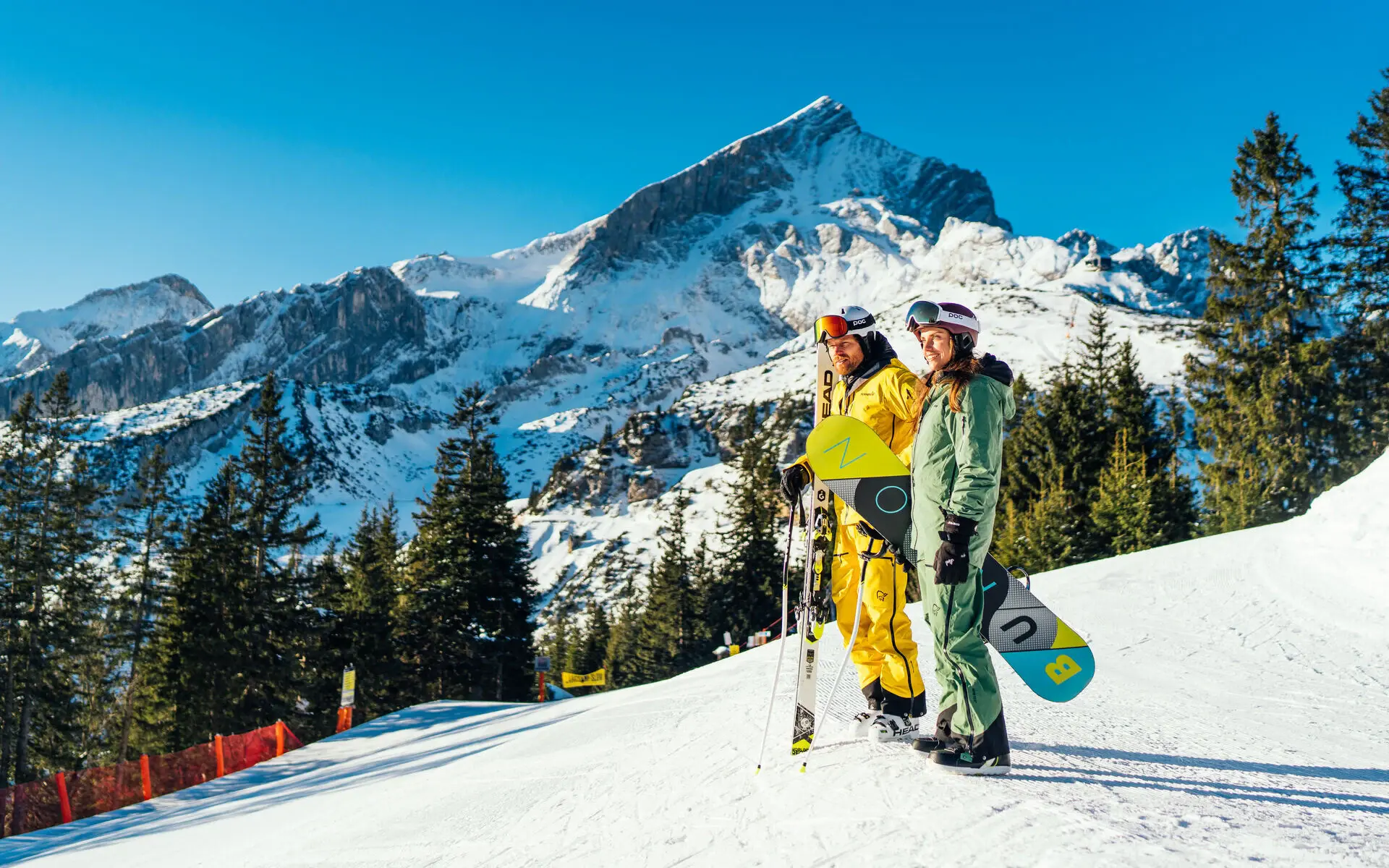 Wintersport in Garmisch-Partenkirchen Zwei Personen in Skiausrüstung stehen auf einem verschneiten Berg.