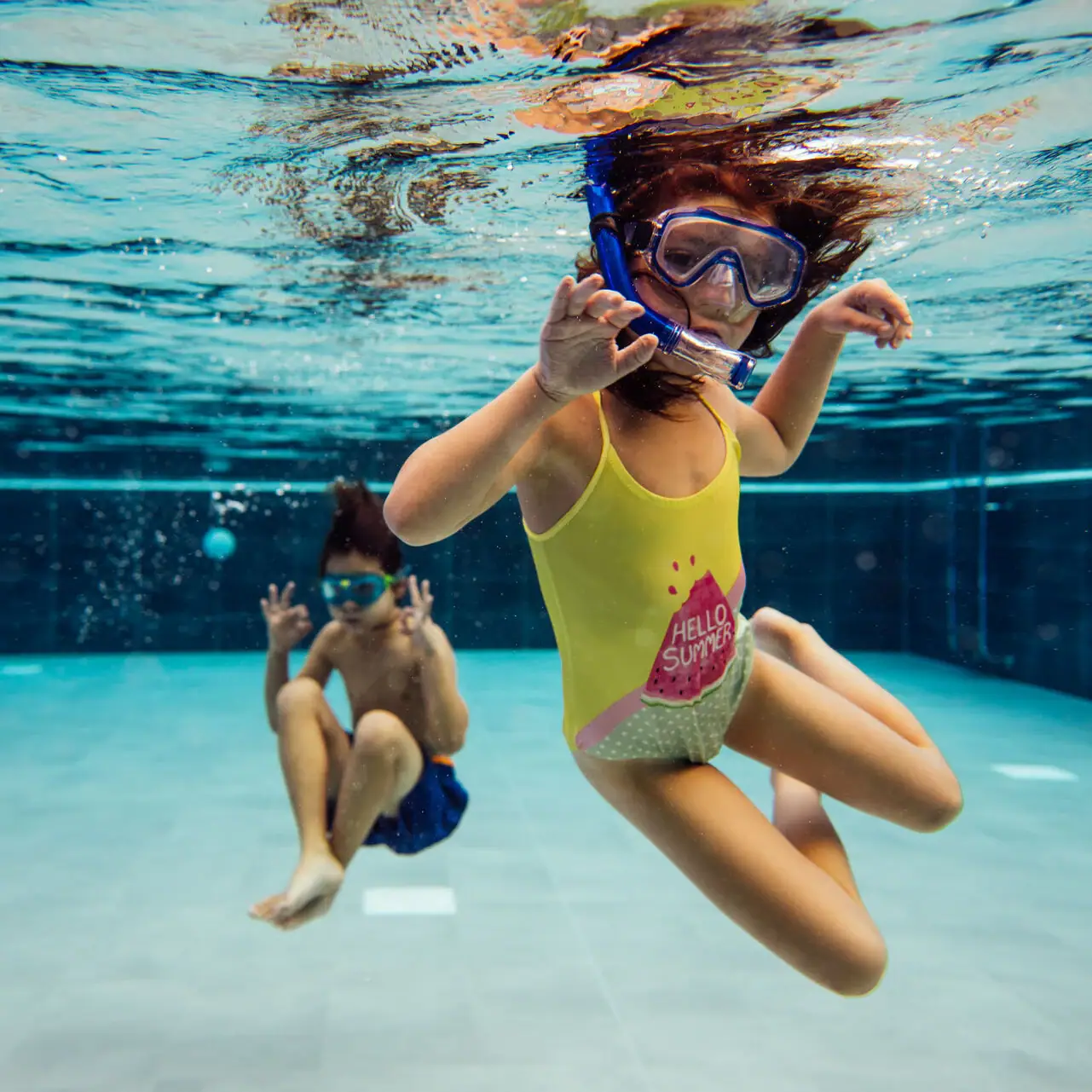 Kinder im Pool Zwei Kinder schwimmen unter Wasser in einem Schwimmbad.