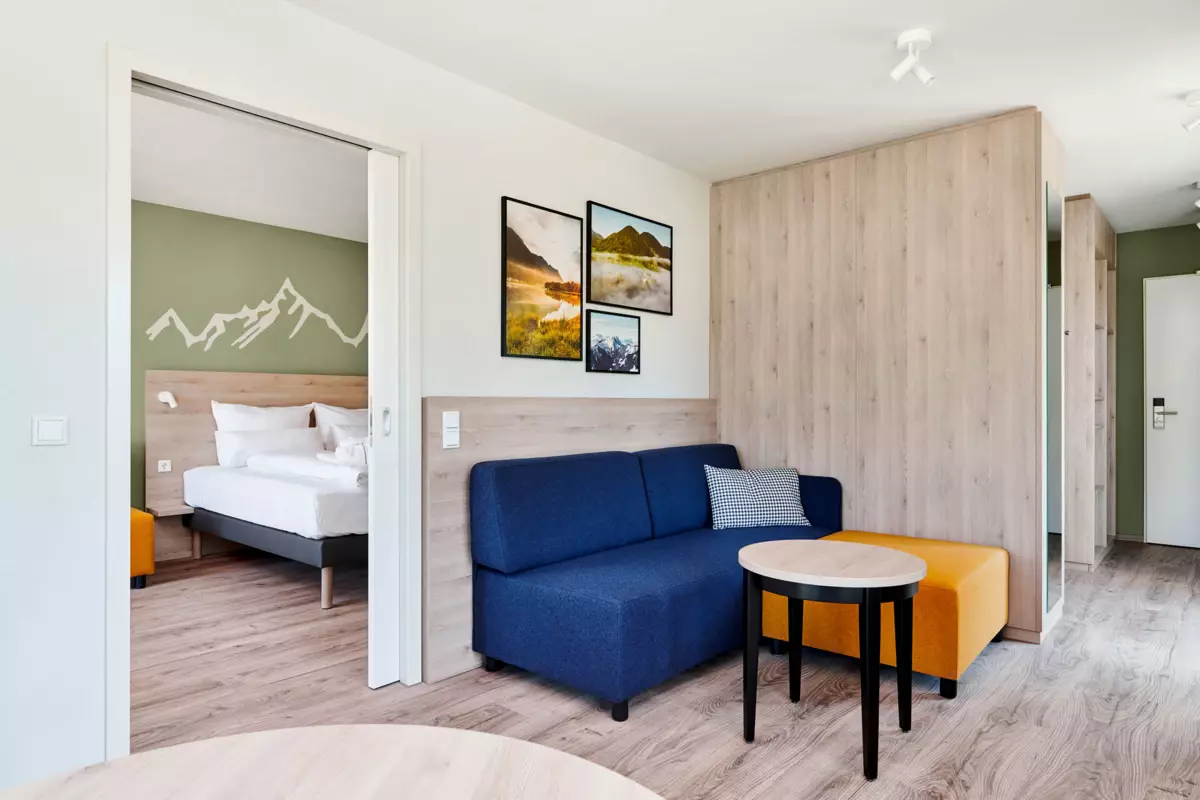 Suite im aja Ruhpolding Ein Raum mit einem Sofa und einem Tisch.
