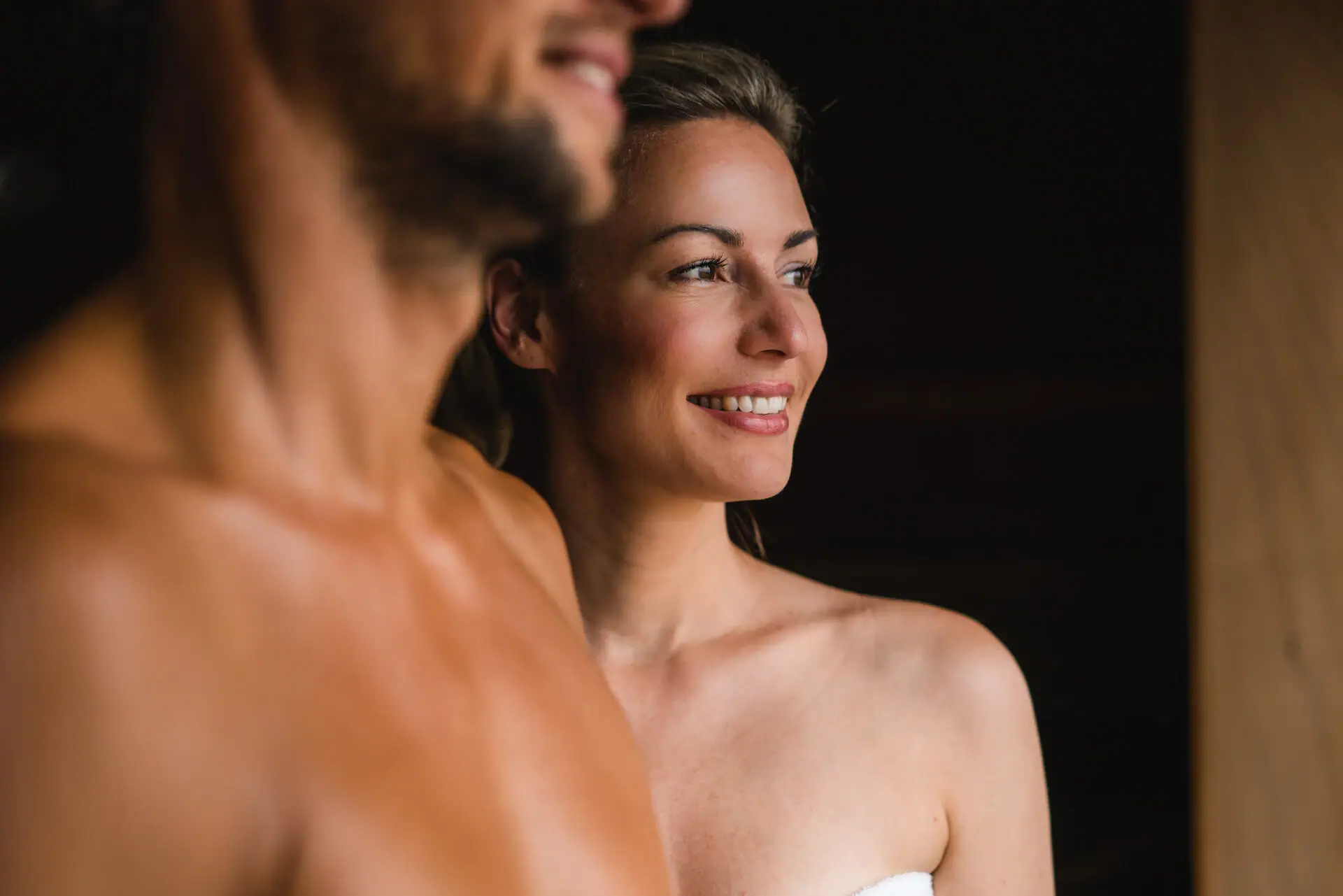 BIO-Sauna im aja Warnemünde Ein Mann und eine Frau lächeln und stehen in einer Sauna.