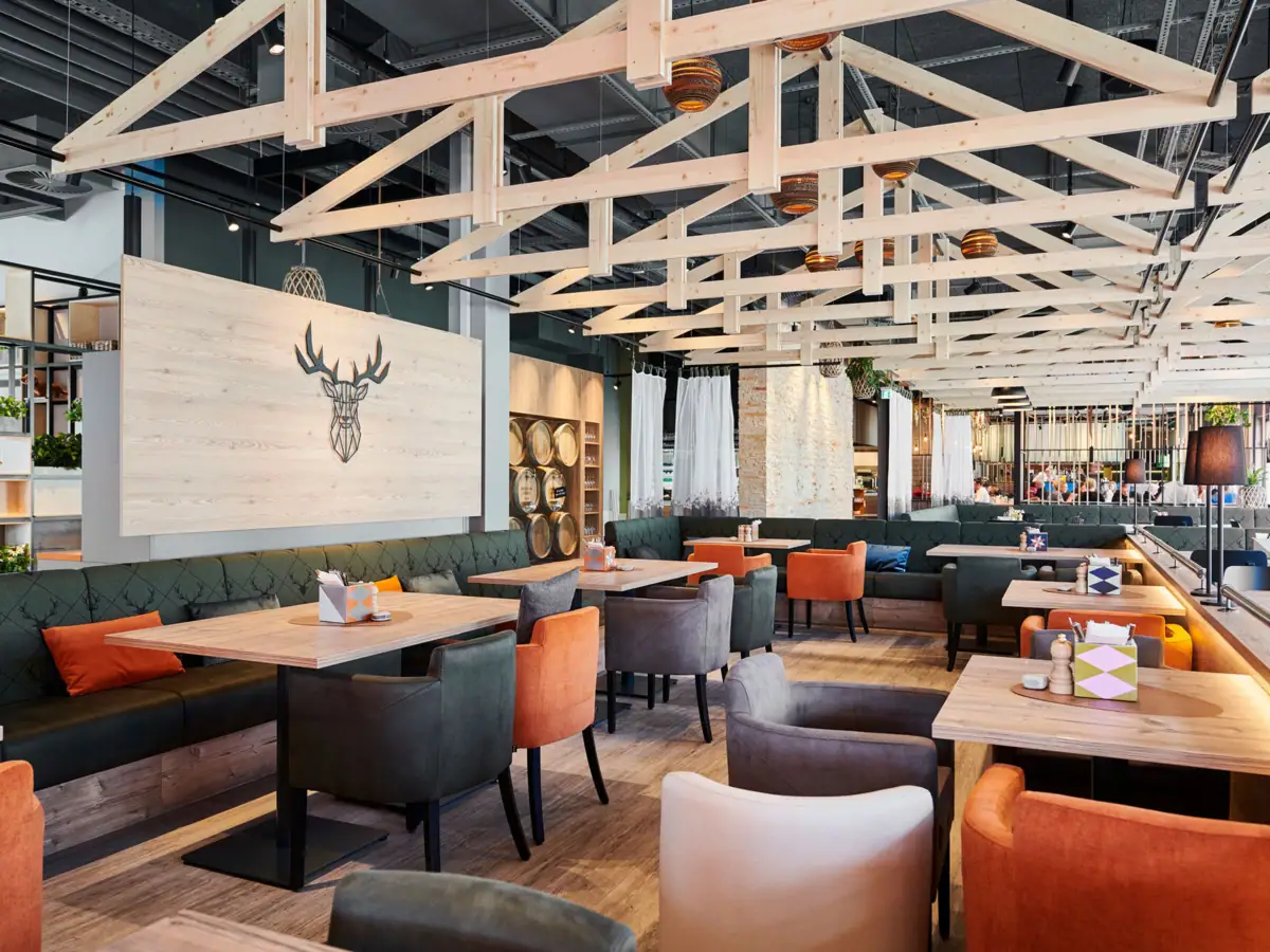 Restaurant im aja Ruhpolding Restaurant mit Tischen und Stühlen im Innenbereich.