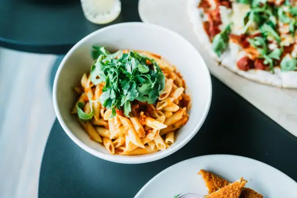 Pasta Eine Schüssel Pasta mit Sauce und Petersilie.