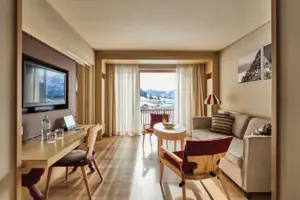 Suite Wohnbereich Ein Raum mit einem Tisch, Stühlen und einem Fernseher.