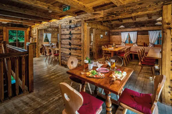 Ein Gastraum mit Tischen und Stühlen sowie einem Tisch mit Essen.