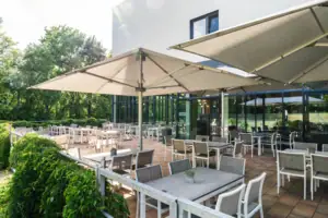 Terrasse Eine Terrasse mit Tischen und Stühlen.