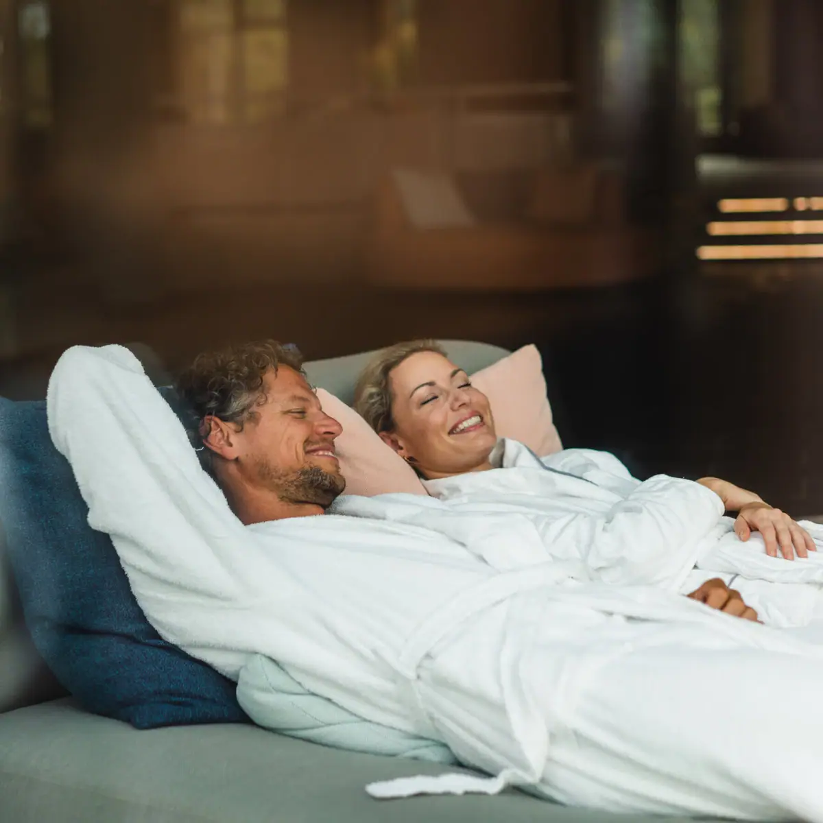 Paar im SPA Ein Mann und eine Frau liegen auf einer Couch.