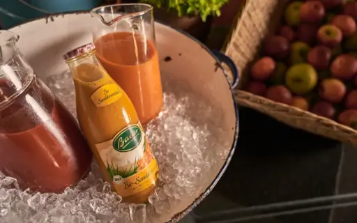 Eine große Wanne mit Eis in der eine Flasche und zwei Karaffen mit Saft stehen. Eine große Wanne mit Eis in der eine Flasche und zwei Karaffen mit Saft stehen.