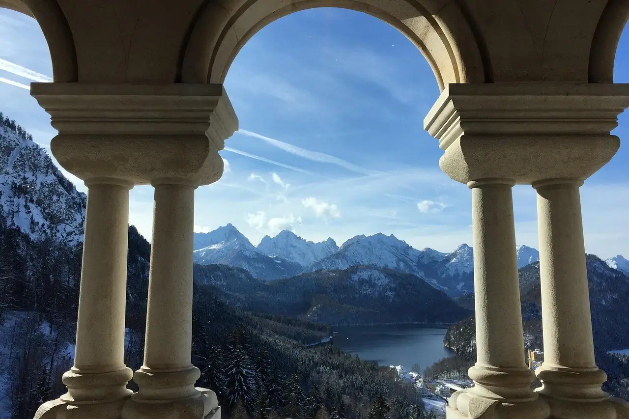 Schloss Neuschwanstein Ausblick Ausblick vom Schloss Neuschwanstein durch einen Steinbogen mit Blick auf Berge und einen See.