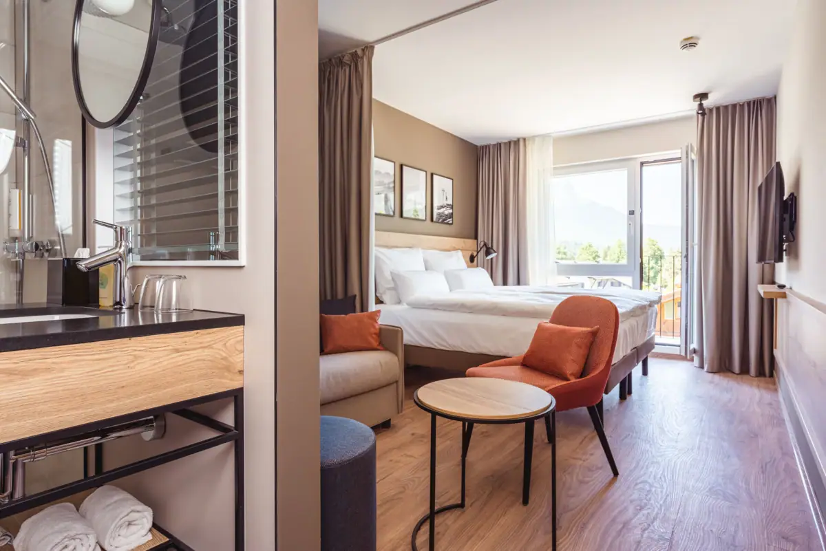 Doppelzimmer Ein Zimmer mit einem Bett und einem Tisch.