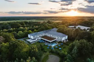 aja Bad Saarow Ein Gebäude mit einem Pool, umgeben von Bäumen.