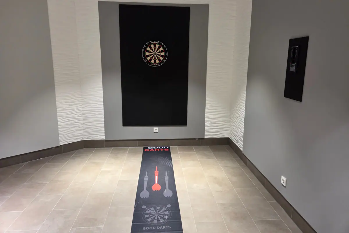 Darts Ein Raum mit einer Dartscheibe und einem Teppich.