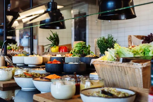 Salatbar Ein Buffet-Tisch mit verschiedenen Speisen und Geschirr.