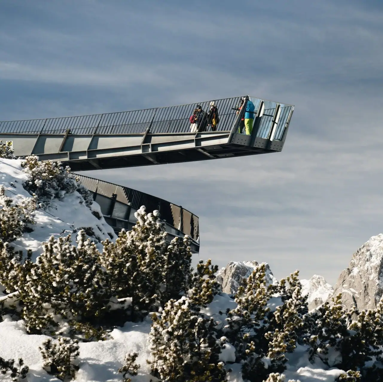 Alpspix Menschen gehen über eine Brücke auf einem schneebedeckten Berg.