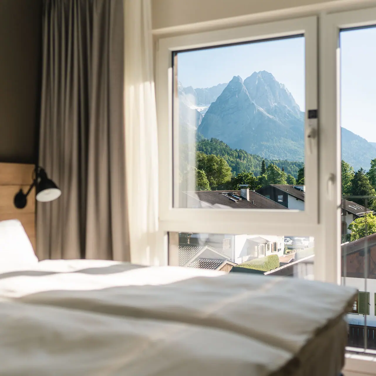 Ausblick aja Garmisch Ein Hotelzimmer im aja Garmisch-Partenkirchen mit Fenster und Blick auf die Berge.