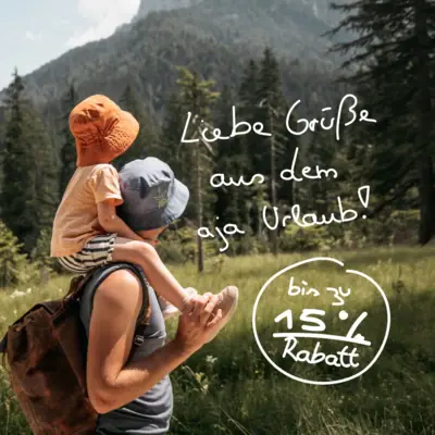 aja Frühlingswochen Ein Mann trägt ein Kind auf seinen Schultern im Freien.