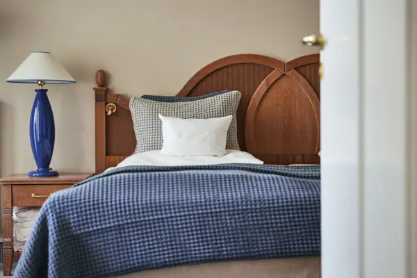 Bett mit blauer Decke und weißem Kissen