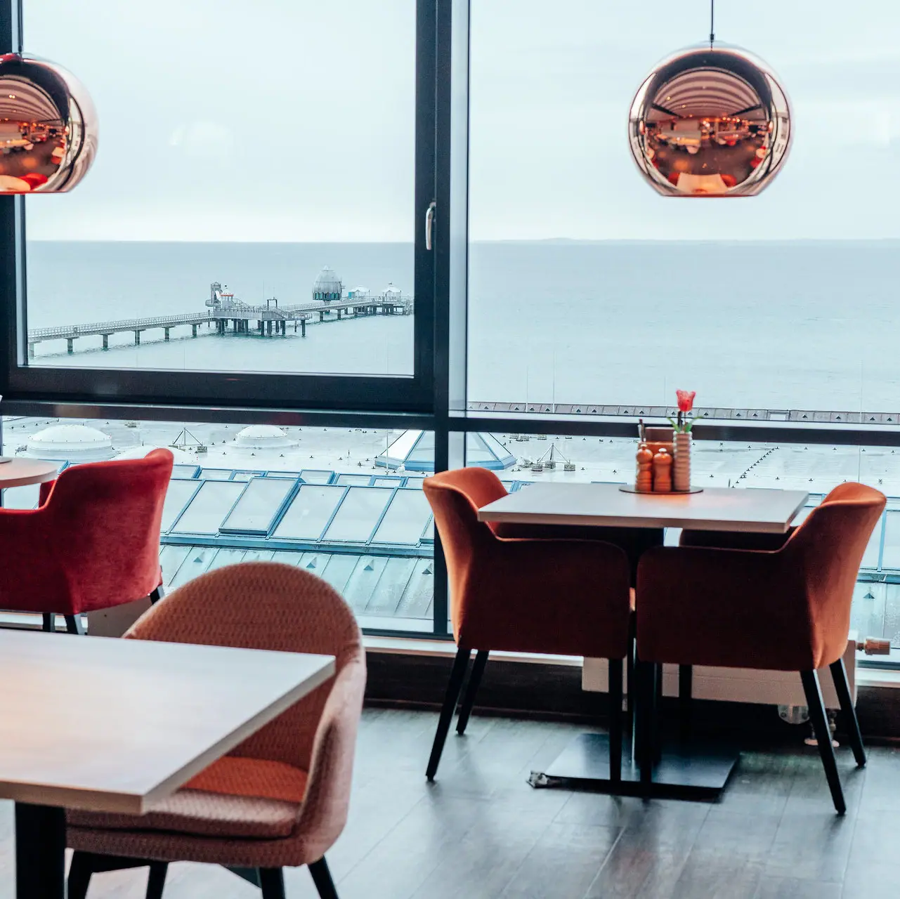 Restaurant Ein Raum mit Blick auf den Ozean und einen Pier.
