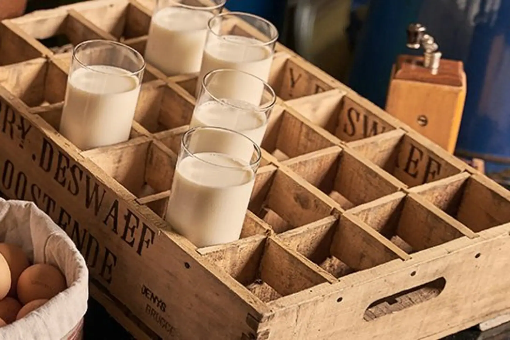 Brot und Eier in einem Korb neben einem Glas Milch