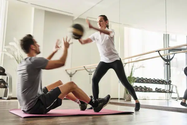 Ein Mann und eine Frau trainieren in einem Fitnessstudio.
