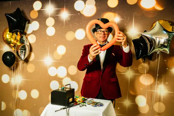 Silvester im aja Travemünde Ein Mann in rotem Anzug bastelt Figuren aus langen Luftballons