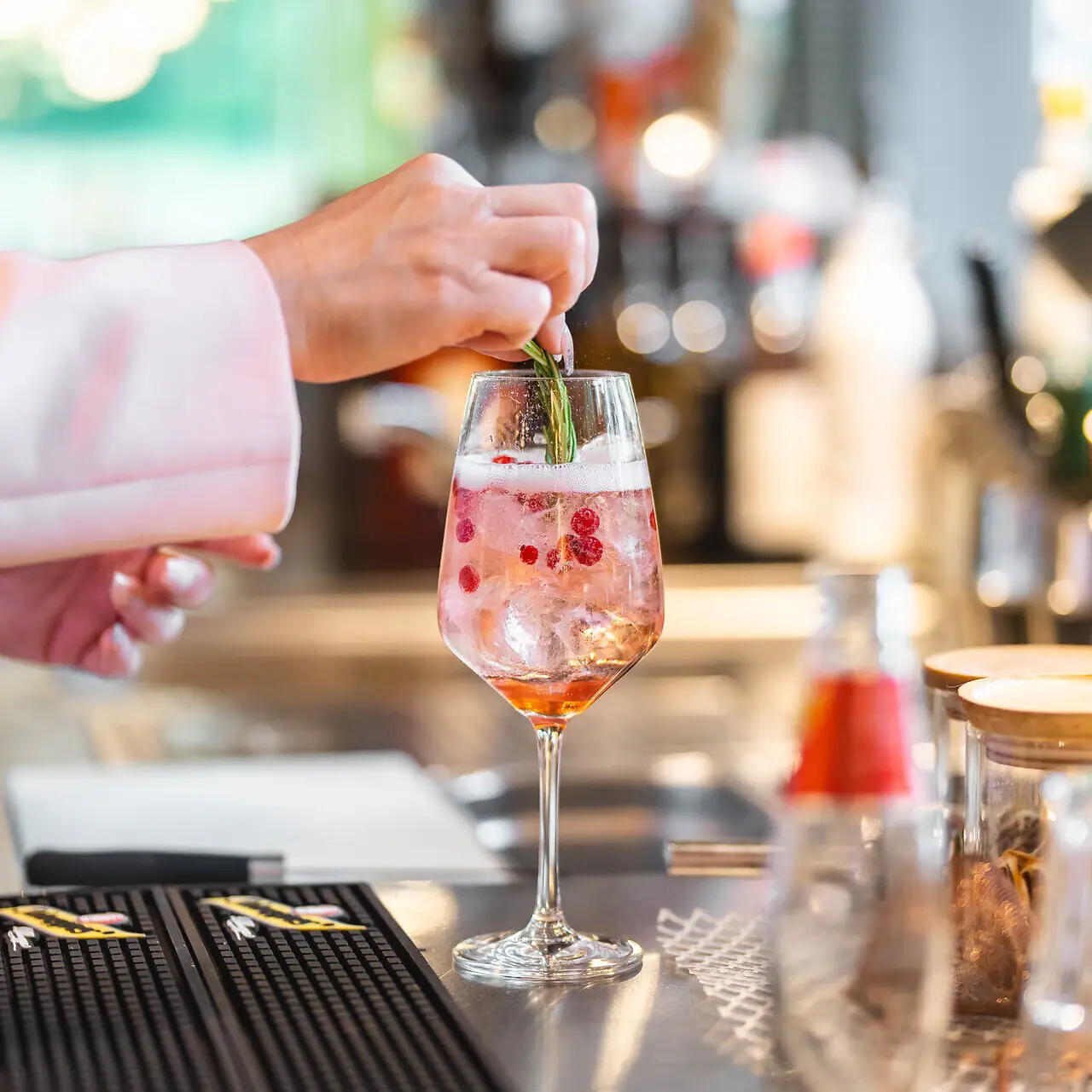 Aperitif Eine Person legt ein Blatt auf ein Getränk in einem Glas.